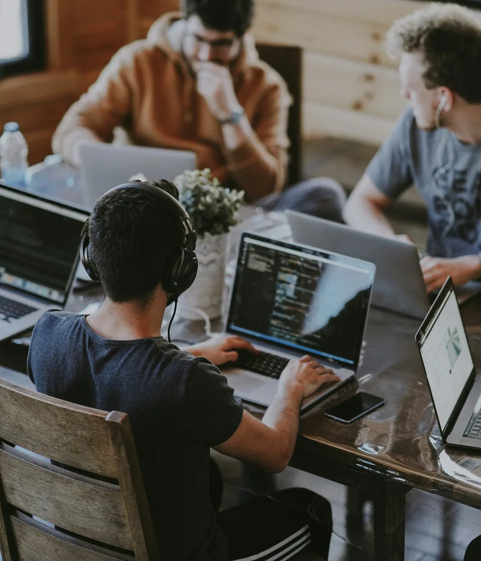 Small team collaborating around laptops during a workflow planning session