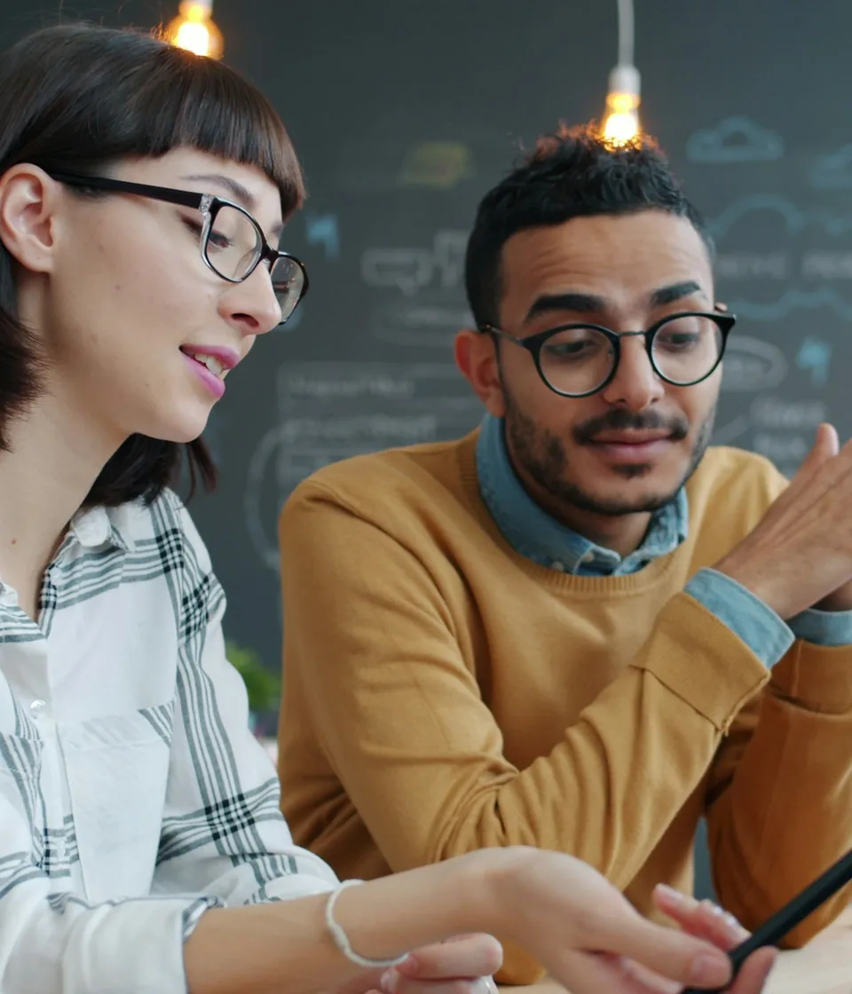 Two coworkers discussing strategy together in an office